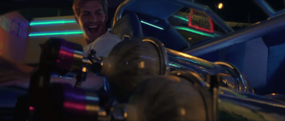 A joyful driver inside a futuristic car, smiling while gripping the steering wheel, with colorful neon lights and modified components visible in the background.